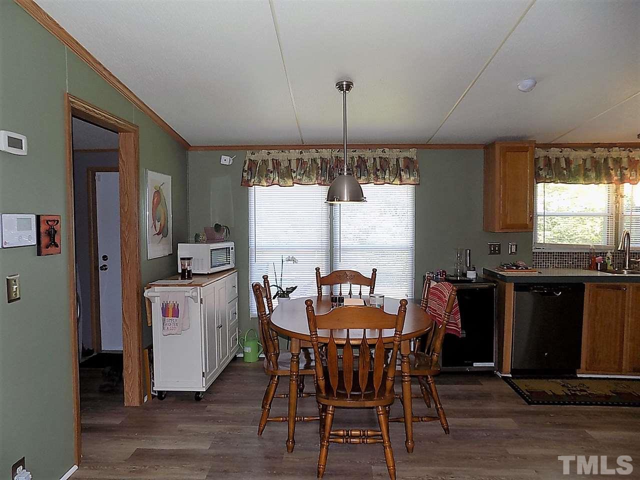 7204 Cedar Tree Street Willow Spring, NC 27592 - Photo 8 of 25 a kitchen with a dining table chairs and refrigerator