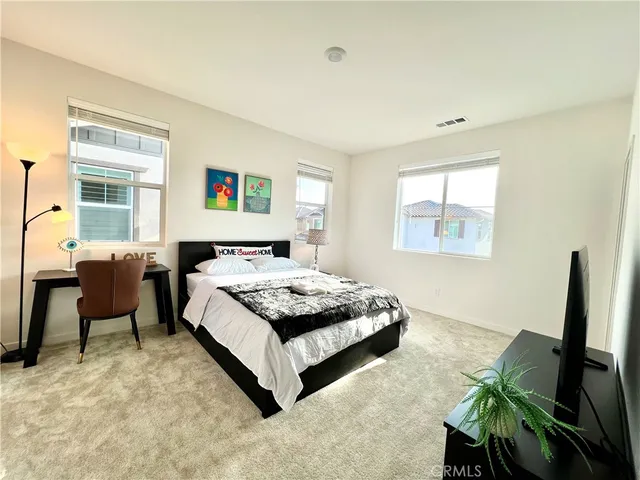 a spacious bedroom with a bed and a desk