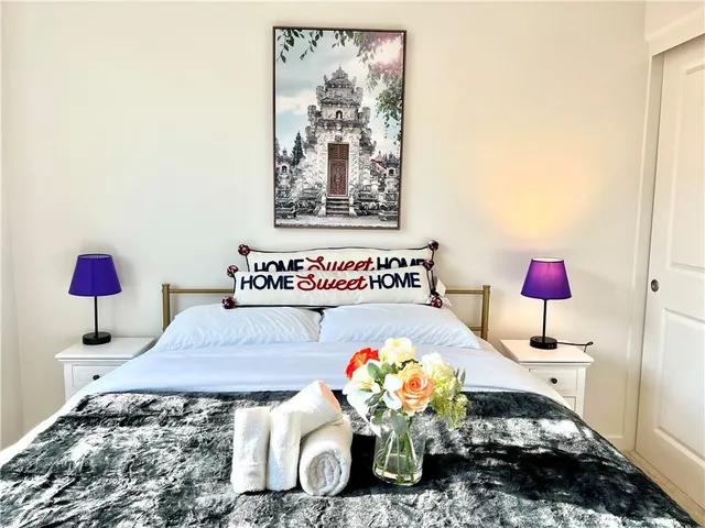 a bedroom with a bed and a lamp on dresser