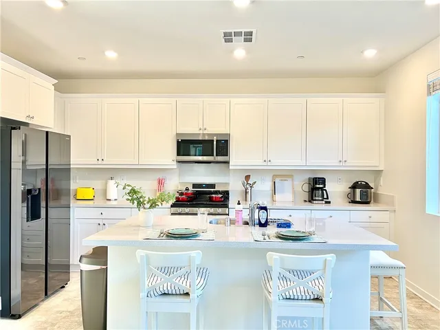 a kitchen with stainless steel appliances a sink a stove a refrigerator cabinets and a counter space