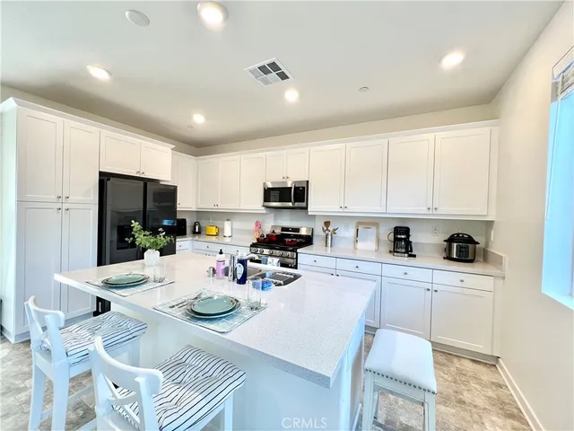 a kitchen with a sink stainless steel appliances and white cabinets