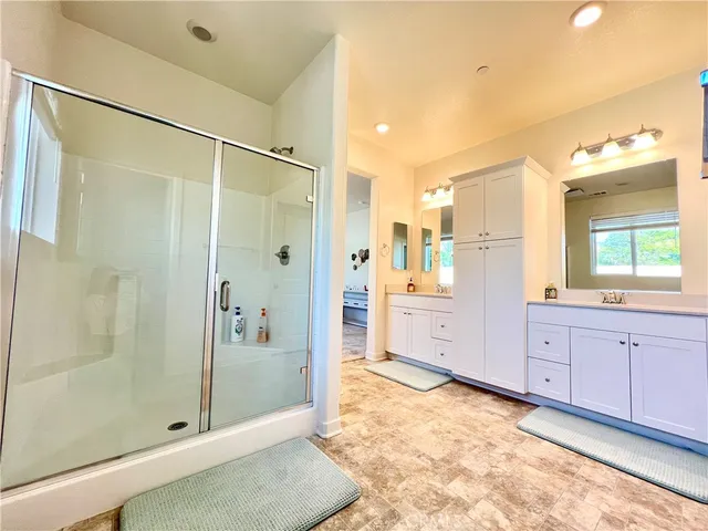 a bathroom with a glass door shower a sink and a mirror