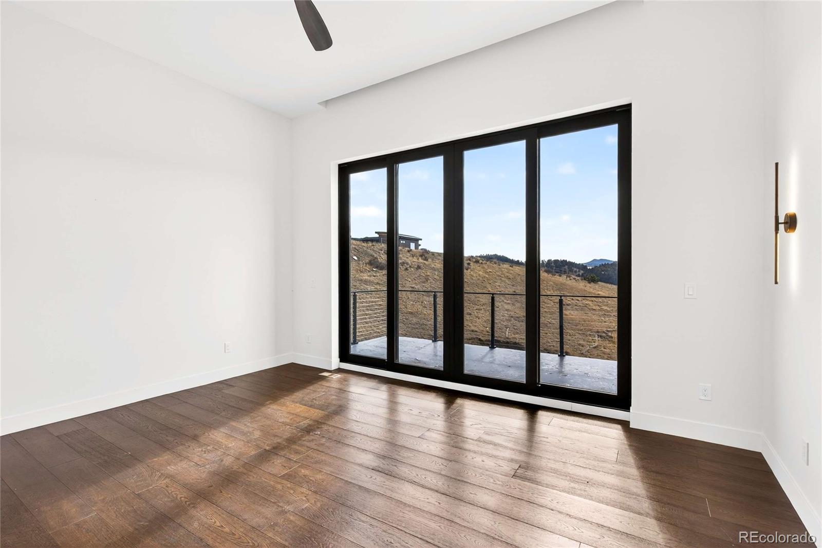 545 Strada Rossa Road Golden, CO 80401 - Photo 14 of 49 an empty room with wooden floor and windows