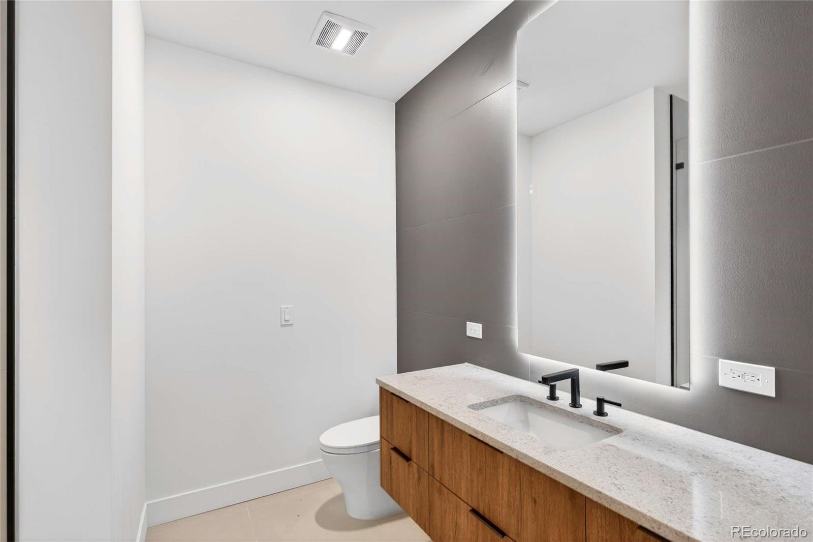 545 Strada Rossa Road Golden, CO 80401 - Photo 18 of 49 a bathroom with a granite countertop sink a toilet and a mirror