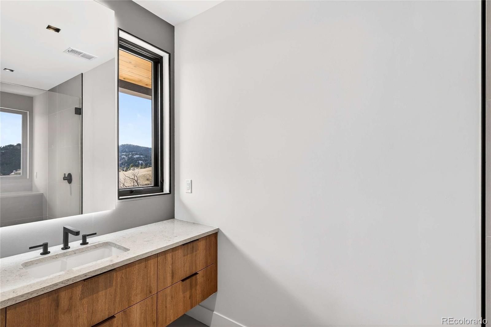 545 Strada Rossa Road Golden, CO 80401 - Photo 23 of 49 a bathroom with a granite countertop sink and a mirror