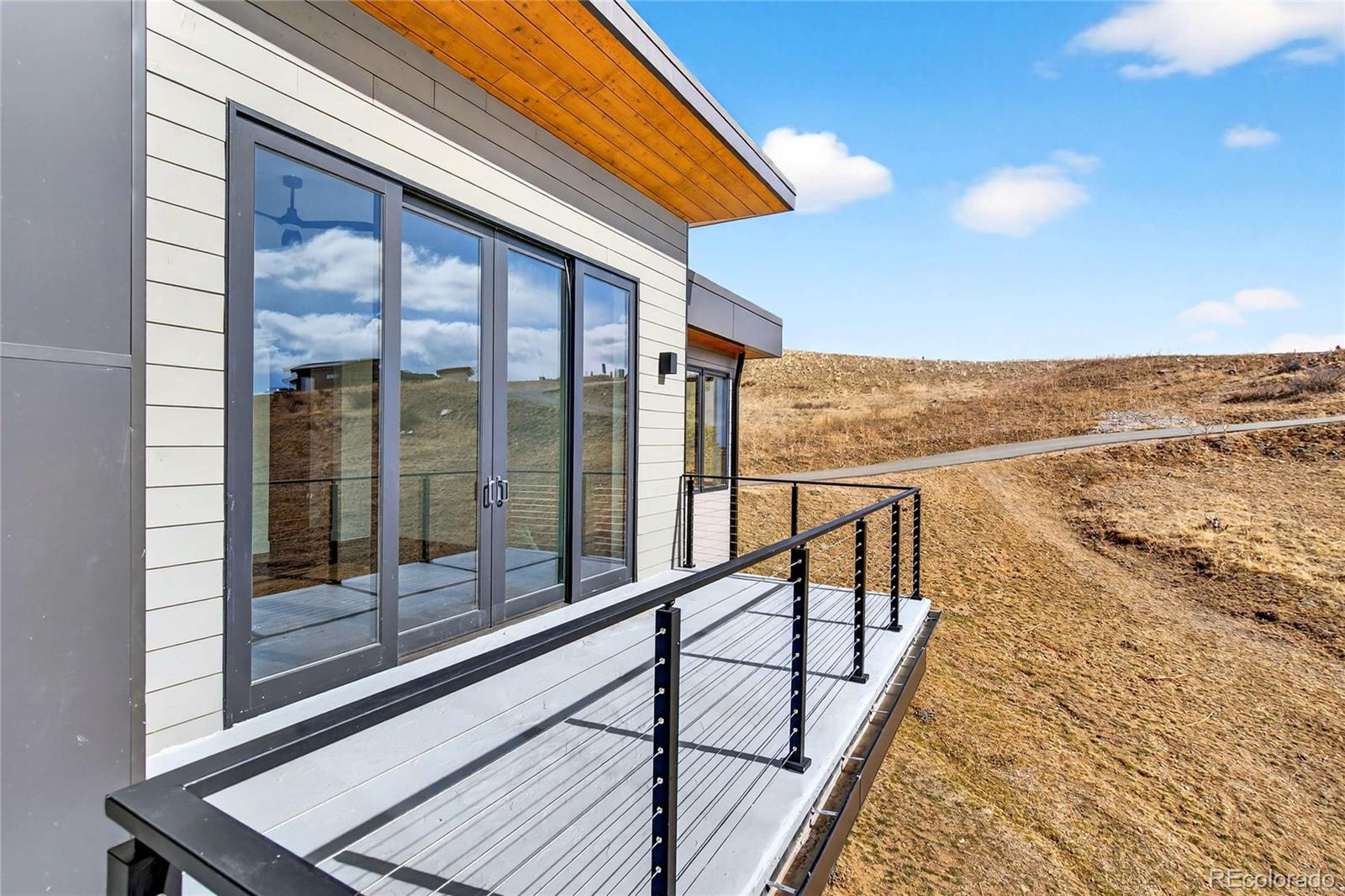 545 Strada Rossa Road Golden, CO 80401 - Photo 28 of 49 a view of a balcony with wooden floor and iron stairs