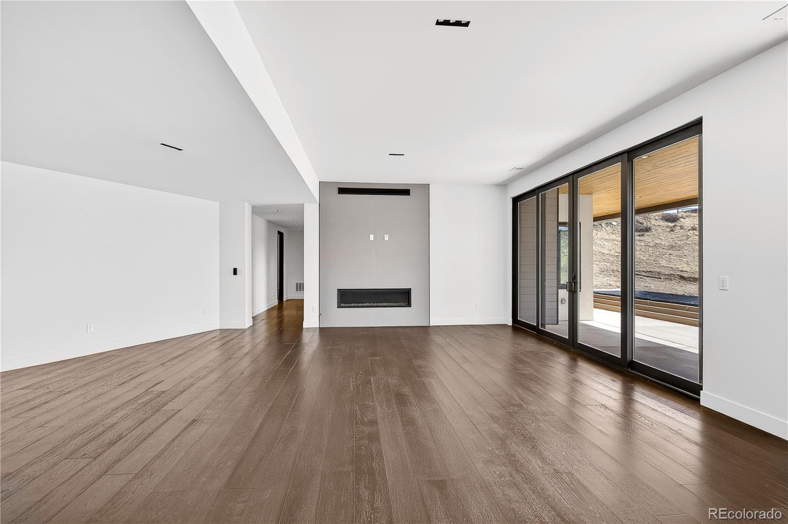 545 Strada Rossa Road Golden, CO 80401 - Photo 45 of 49 an empty room with wooden floor and windows
