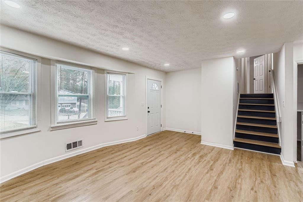 862 Sheppard Way Stone Mountain, GA 30083 - Photo 4 of 22 a view of an empty room with wooden floor and a window