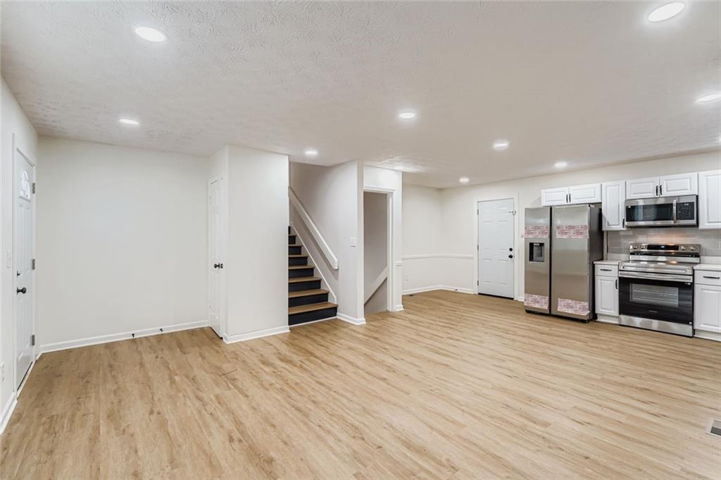 862 Sheppard Way Stone Mountain, GA 30083 - Photo 5 of 22 an empty room with wooden floor and staircase