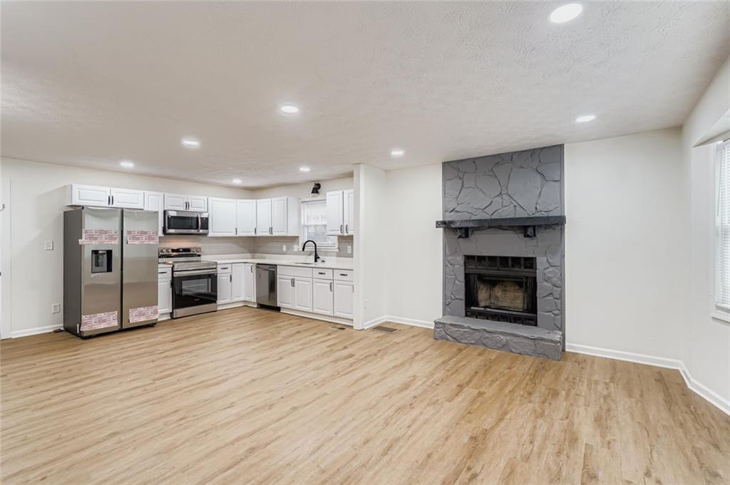 862 Sheppard Way Stone Mountain, GA 30083 - Photo 6 of 22 a open kitchen with stainless steel appliances granite countertop a stove top oven a sink and a refrigerator