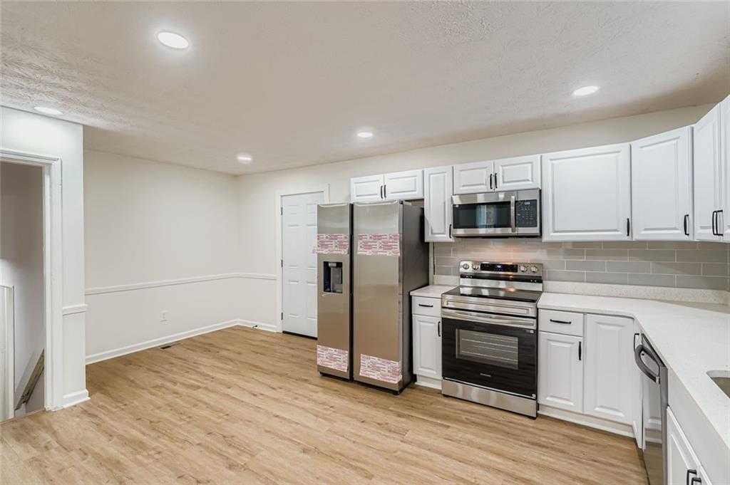 862 Sheppard Way Stone Mountain, GA 30083 - Photo 8 of 22 a kitchen with stainless steel appliances a stove refrigerator and microwave