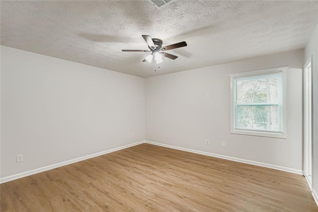 862 Sheppard Way Stone Mountain, GA 30083 - Photo 10 of 22 wooden floor in an empty room with a window