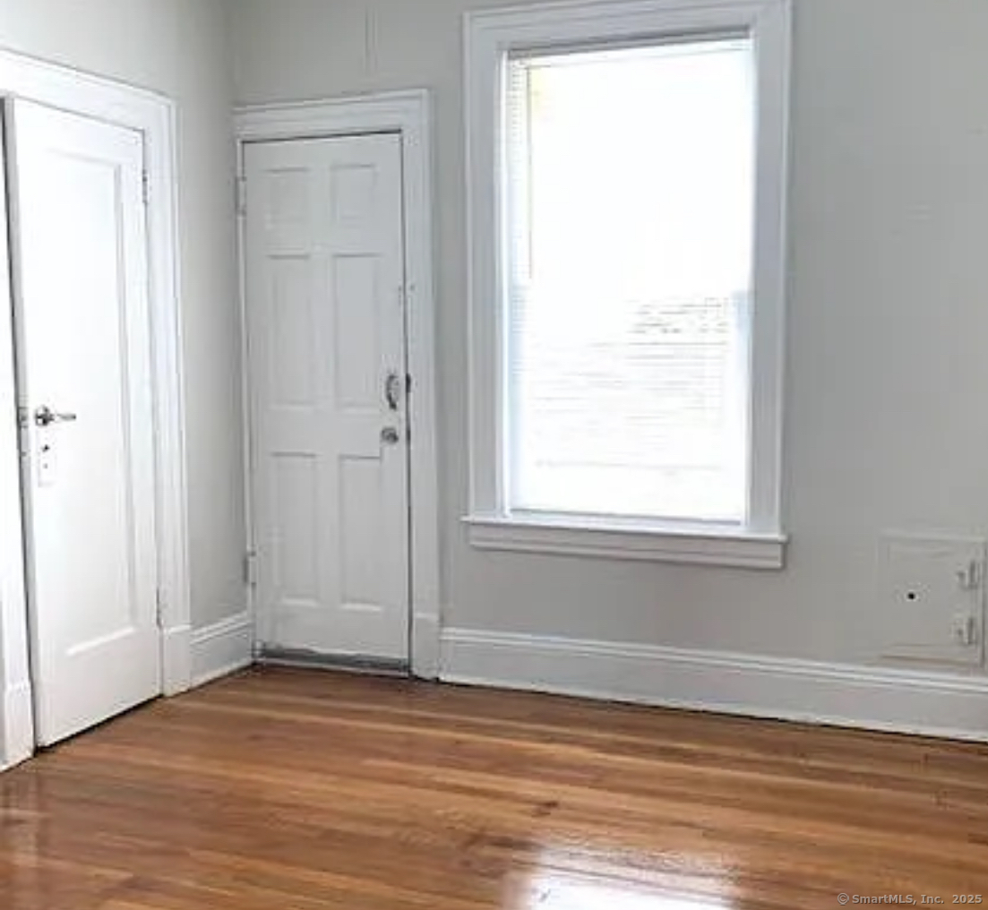 1589 Fairfield Avenue, Unit 7 Bridgeport, CT 06605 - Photo 2 of 3 an empty room with wooden floor and a window