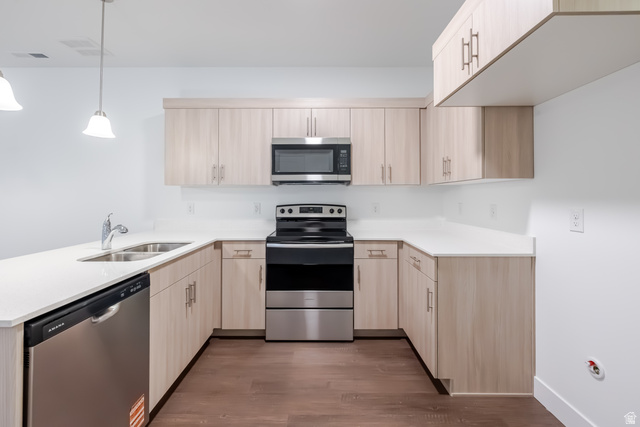 4704 Olive Avenue, Unit V202 Mapleton, UT 84664 - Photo 12 of 17 U-shaped kitchen with light wood-finish cabinetry, white countertops, stainless steel appliances, and wood-finish flooring