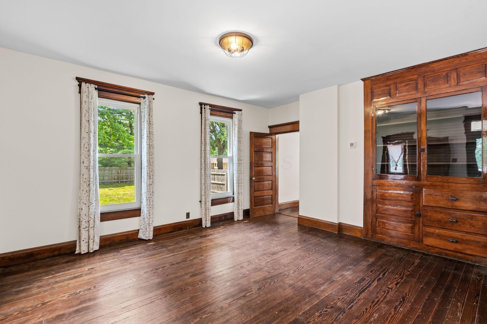 107 Price Road Columbus, OH 43230 - Photo 12 of 51 Hardwood flooring throughout featuring a built-in wooden cabinet with glass-fronted upper doors and lower drawers
