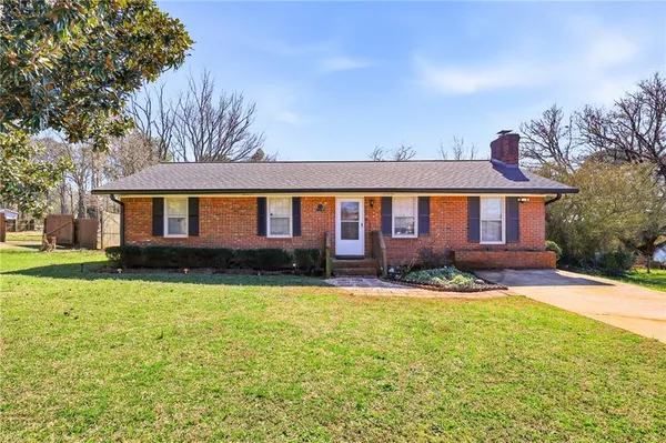 a front view of a house with a yard and trees