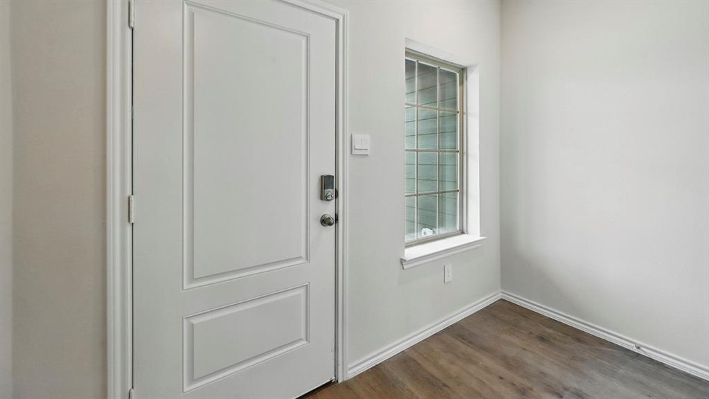232 Pheasant Run Road Terrell, TX 75160 - Photo 17 of 36 Entryway featuring a paneled door with smart lock hardware, a multi-paned window, neutral wall paint, and wood-finish flooring