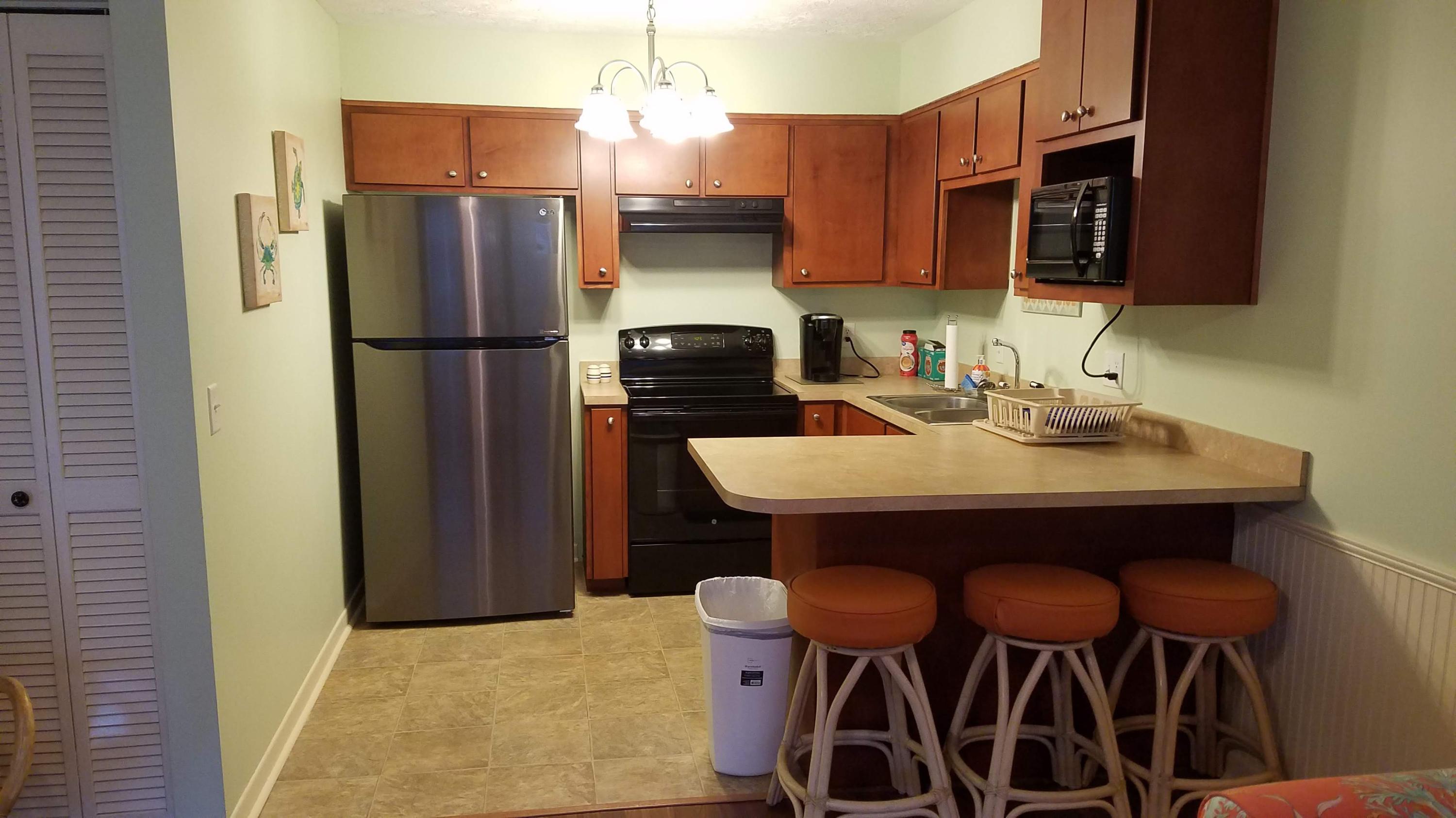 17670 Front Beach Road, Unit D3 Panama City Beach, FL 32413 - Photo 4 of 12 a kitchen with stainless steel appliances a refrigerator a sink a stove and cabinets