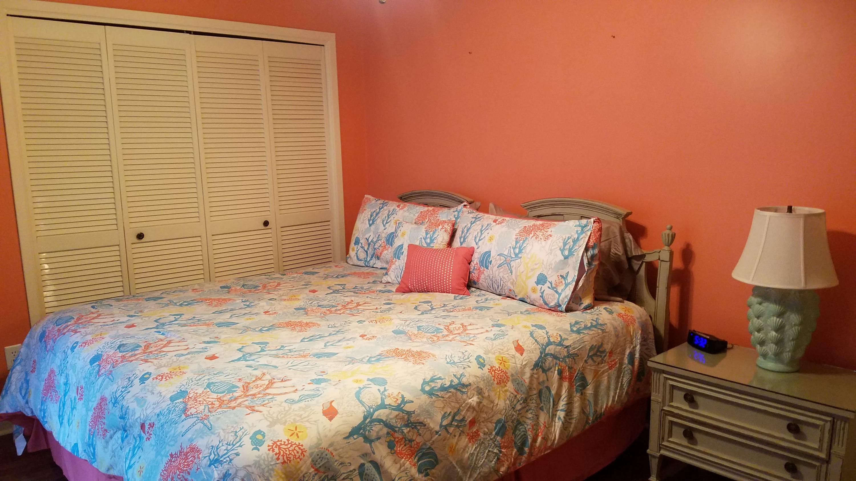 17670 Front Beach Road, Unit D3 Panama City Beach, FL 32413 - Photo 6 of 12 a bedroom with a bed and a lamp on dresser