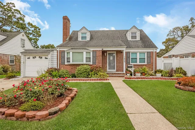 a front view of a house with a garden and plants