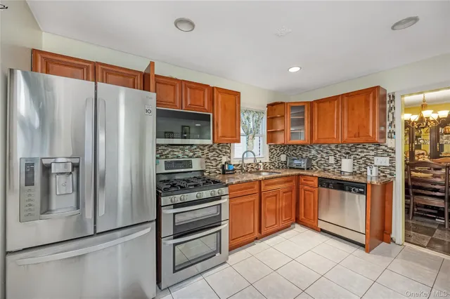 a kitchen with stainless steel appliances granite countertop a refrigerator and a stove top oven