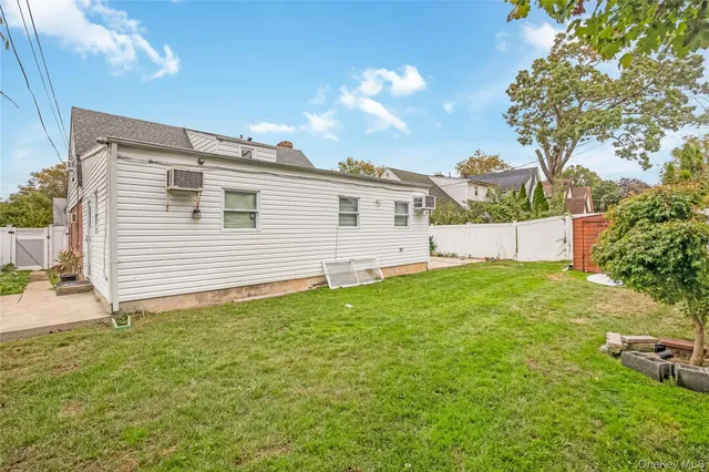 a view of a backyard with plants and a large tree