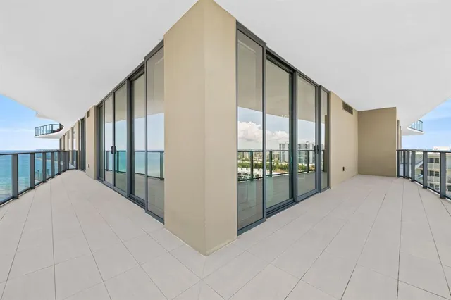 a view of a bedroom with floor to ceiling window and a balcony