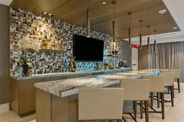 a view of a kitchen with a sink and a flat screen tv