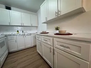 a kitchen with white cabinets and white appliances