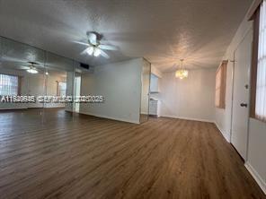 13550 Southwest 6th Court, Unit 113A Pembroke Pines, FL 33027 - Photo 5 of 12 a view of an empty room with wooden floor and a kitchen