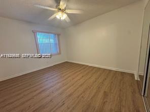13550 Southwest 6th Court, Unit 113A Pembroke Pines, FL 33027 - Photo 7 of 12 an empty room with wooden floor and windows