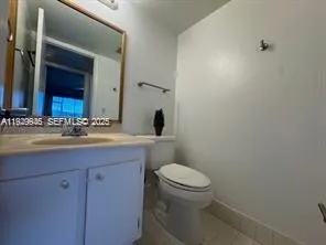 a bathroom with a granite countertop sink a toilet and a mirror