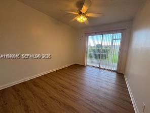 13550 Southwest 6th Court, Unit 113A Pembroke Pines, FL 33027 - Photo 9 of 12 an empty room with wooden floor and fan