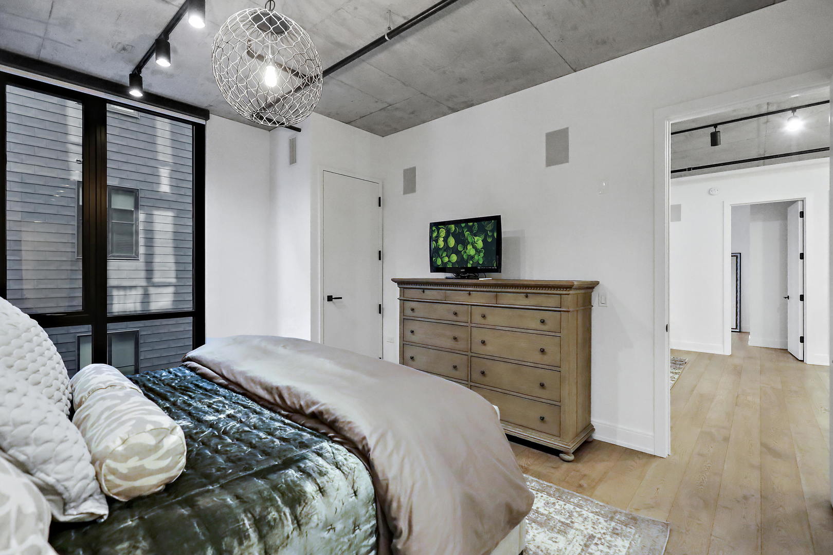 111 South Peoria Street, Unit 406 Chicago, IL 60607 - Photo 18 of 26 a spacious bedroom with a bed and a dresser