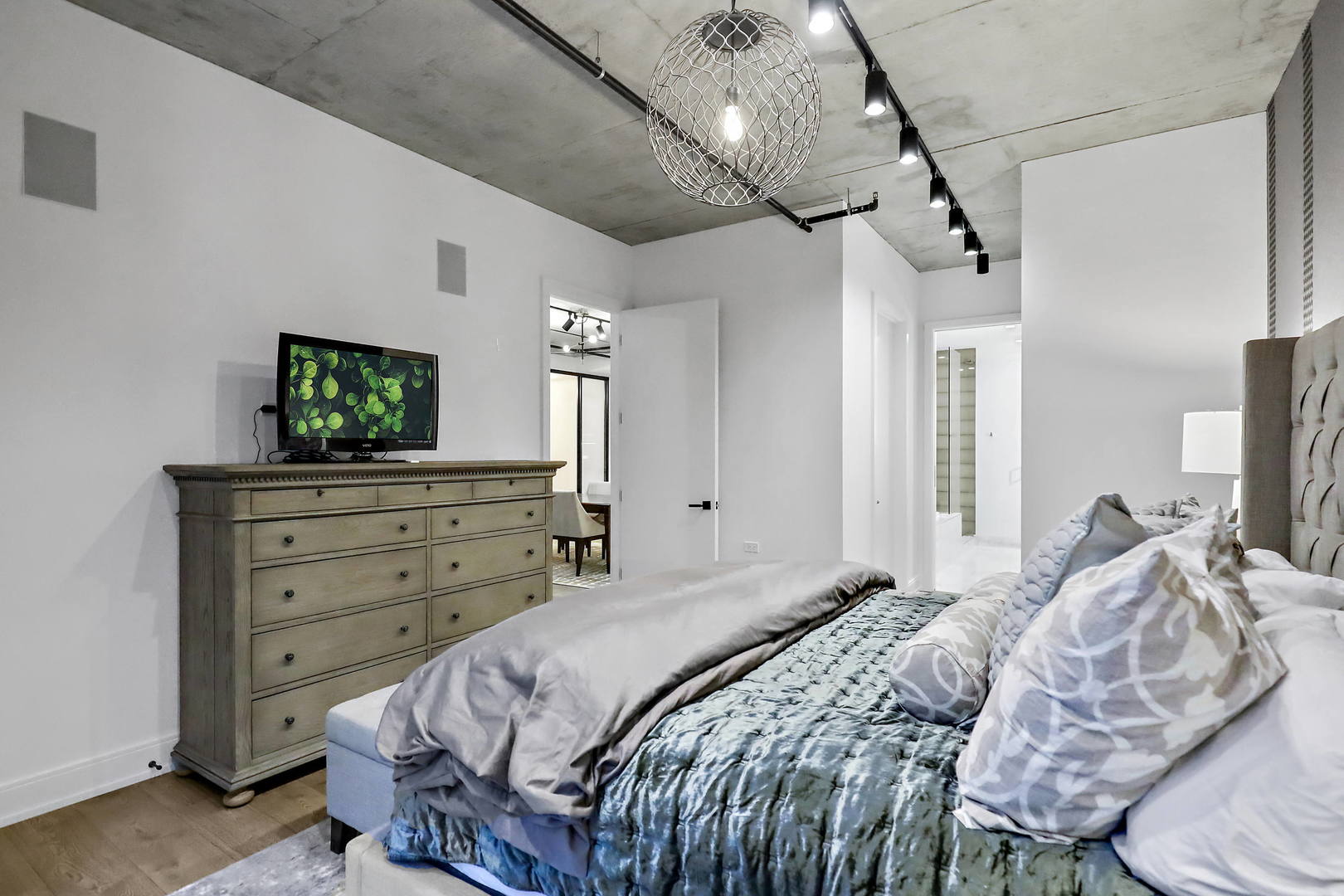 111 South Peoria Street, Unit 406 Chicago, IL 60607 - Photo 19 of 26 a bedroom with a bed and a flat screen tv