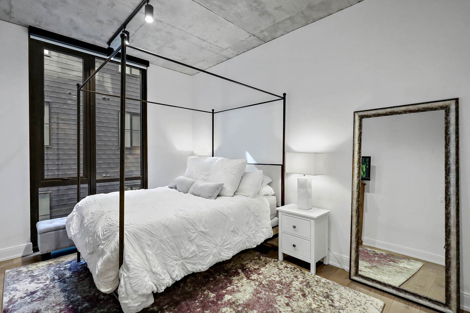 111 South Peoria Street, Unit 406 Chicago, IL 60607 - Photo 23 of 26 a bedroom with a large bed and a chandelier