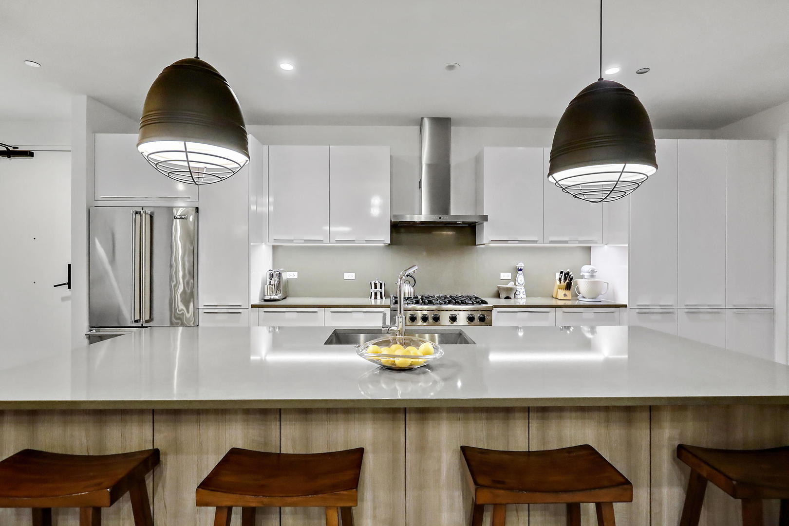 111 South Peoria Street, Unit 406 Chicago, IL 60607 - Photo 7 of 26 a kitchen with stainless steel appliances granite countertop a table chairs in it and a wooden floors