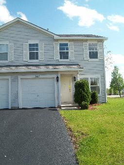 387 Reston Circle, Unit 387 Romeoville, IL 60446 - Photo 1 of 1 a front view of house with yard and green space
