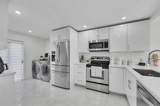 a kitchen with white cabinets and stainless steel appliances