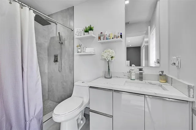 a bathroom with a granite countertop sink toilet and shower