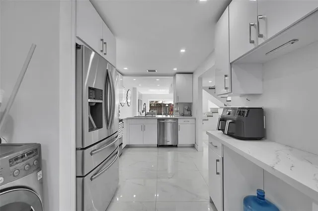 a kitchen with white cabinets and white appliances