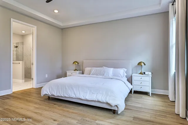 a bedroom with a bed and wooden floor