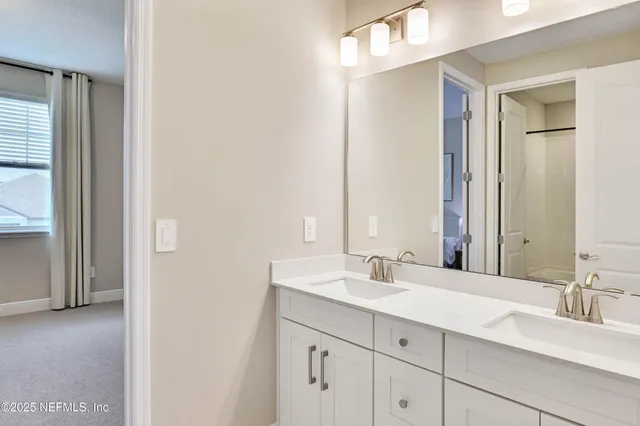 a white bath tub sitting next to a white toilet and vanity