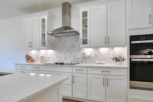 a kitchen with white cabinets and appliances