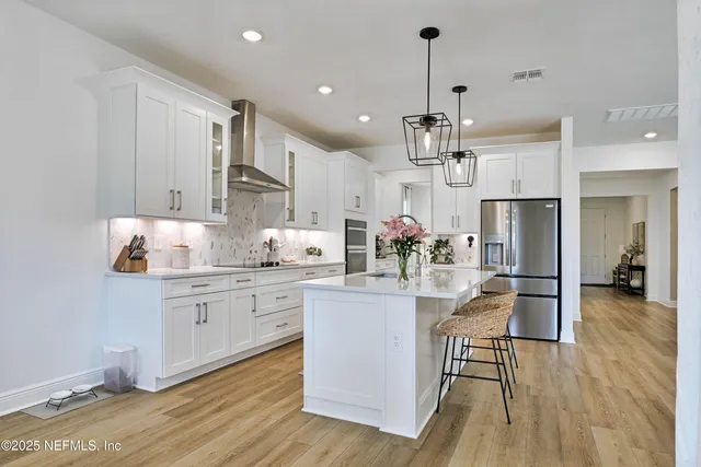 a kitchen with kitchen island granite countertop lots of counter top space and stainless steel appliances