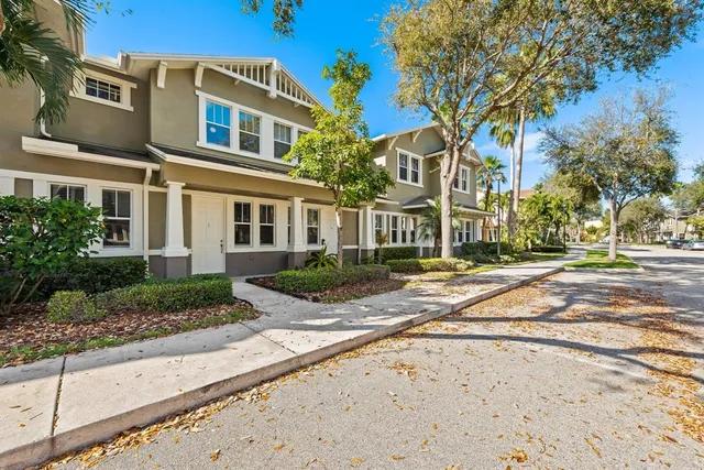 a view of a brick house next to a yard with potted plants
