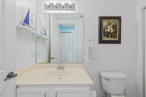 a view of a hallway to a livingroom with wooden floor and stairs