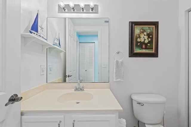 a view of a hallway to a livingroom with wooden floor and stairs