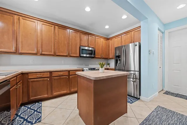 a kitchen with kitchen island granite countertop a sink stove and refrigerator