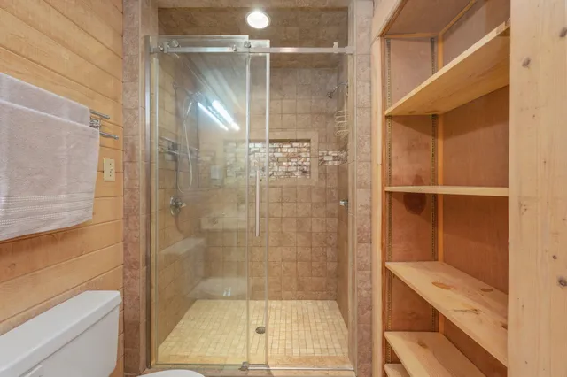 wooden floor with ceiling fan in window